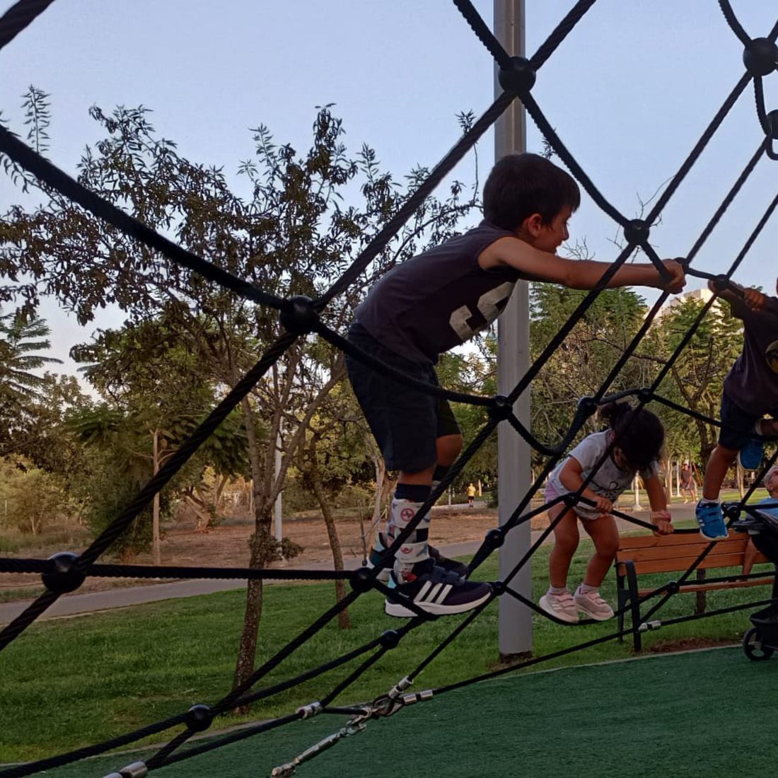 Kids wearing Lairos AFO socks climb a playground net outdoors, showcasing comfort and support.