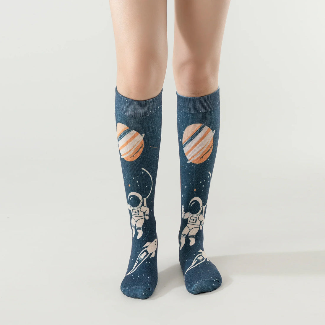 Kids wearing LAIROS space-themed AFO socks with astronaut and planet design, knee-high cotton blend.